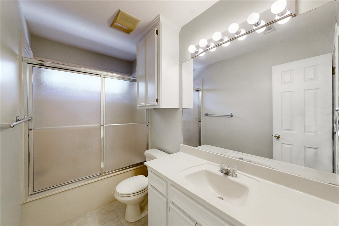 5901 Sheffield Terrace Lane Bryan, TX 77802 - Photo 20 of 31 Full bathroom with enclosed tub / shower combo, vanity, and light tile flooring
