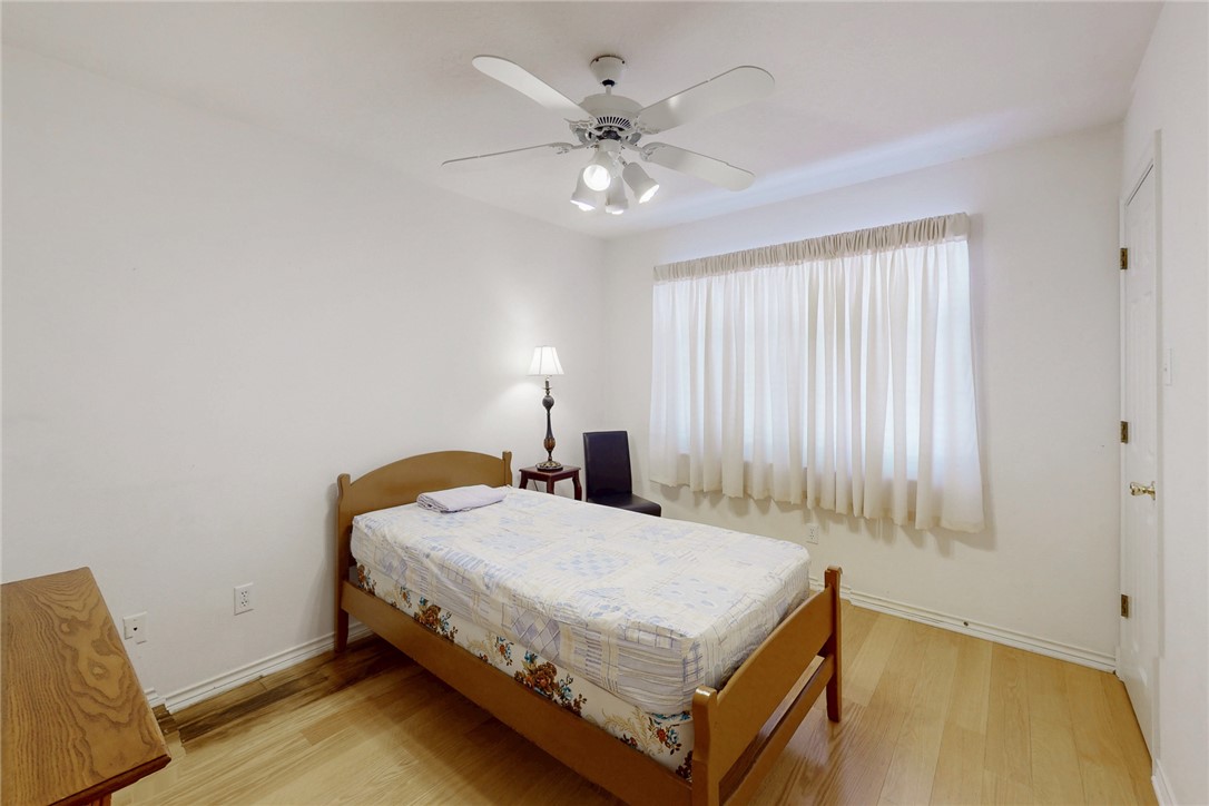 5901 Sheffield Terrace Lane Bryan, TX 77802 - Photo 21 of 31 Guest bedroom with large walk-in closet, ceiling fan with light fixture, light laminate flooring, large window allowing natural light