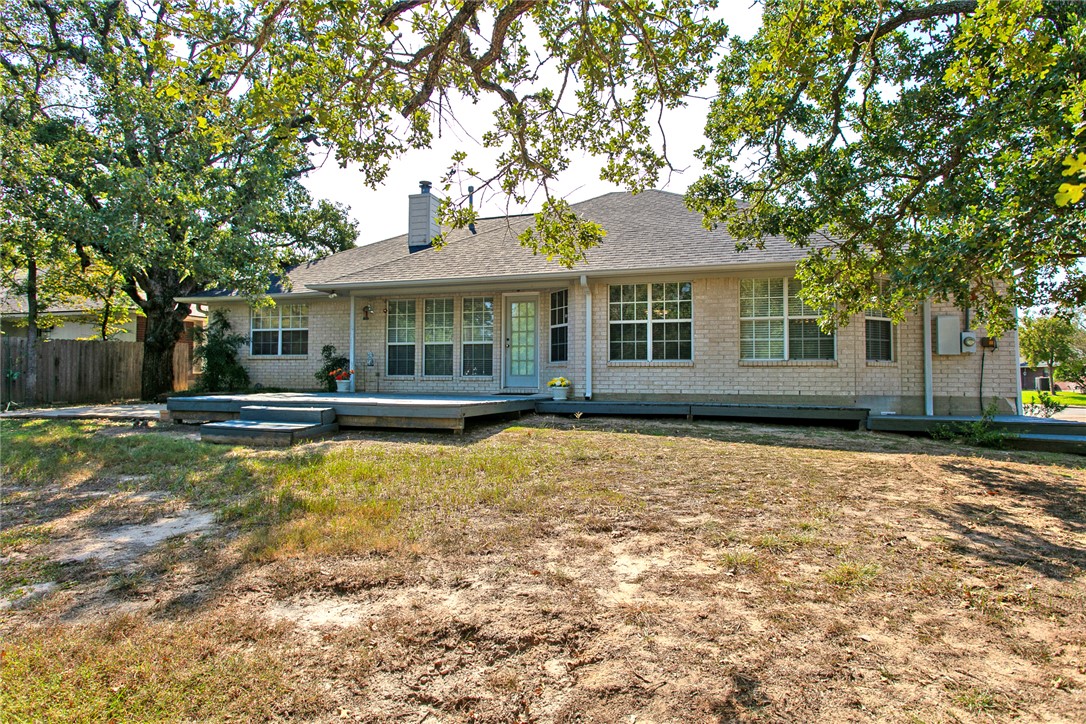 5901 Sheffield Terrace Lane Bryan, TX 77802 - Photo 27 of 31 Backyard view of yard and house with covered patio and deck and new shingled roof