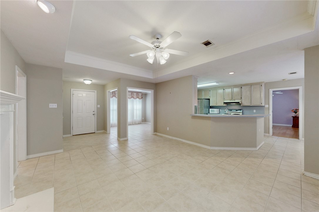 5901 Sheffield Terrace Lane Bryan, TX 77802 - Photo 31 of 31 Family room with an open, flowing floor plan into dining room, kitchen, and breakfast area with continuous light tile flooring.