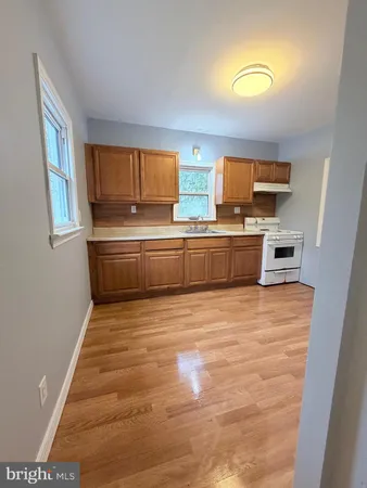 a room with kitchen island a stove a microwave and sink