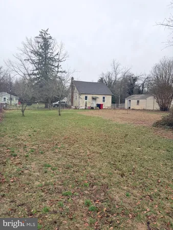 a brick house with a big yard and large trees