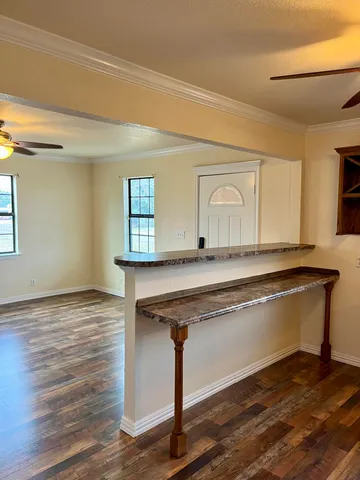a living room with granite countertop a couch and wooden floor