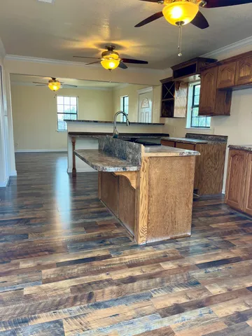 a kitchen with kitchen island a sink and a stove