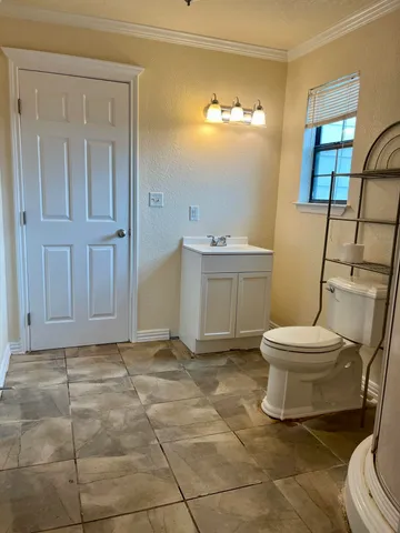 a bathroom with a toilet a sink and mirror
