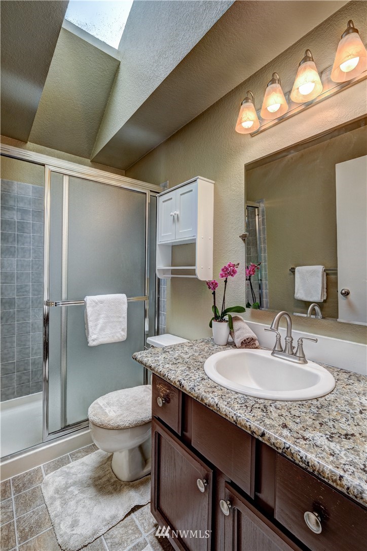 23221 13th Place West Bothell, WA 98021 - Photo 16 of 29 a bathroom with a granite countertop sink toilet and shower