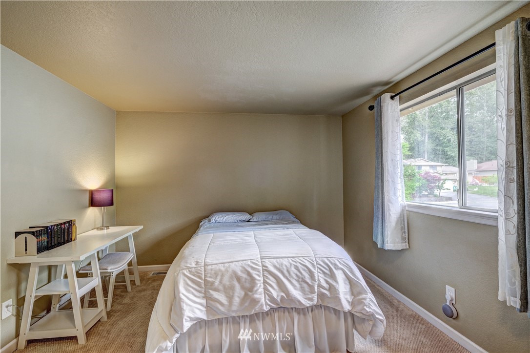 23221 13th Place West Bothell, WA 98021 - Photo 17 of 29 a bedroom with a bed and a table in it