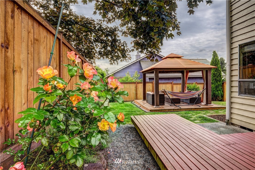 23221 13th Place West Bothell, WA 98021 - Photo 23 of 29 a view of a patio with table and chairs under an umbrella with wooden fence