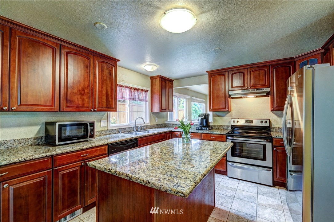 23221 13th Place West Bothell, WA 98021 - Photo 7 of 29 a kitchen with stainless steel appliances granite countertop a sink stove and refrigerator