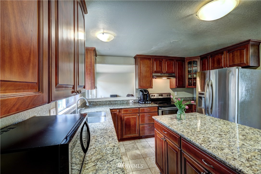 23221 13th Place West Bothell, WA 98021 - Photo 9 of 29 a kitchen with stainless steel appliances granite countertop a sink stove and refrigerator