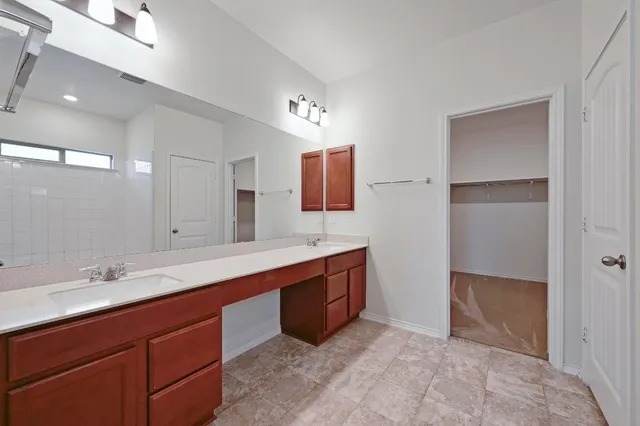 a spacious bathroom with a double vanity sink and mirror
