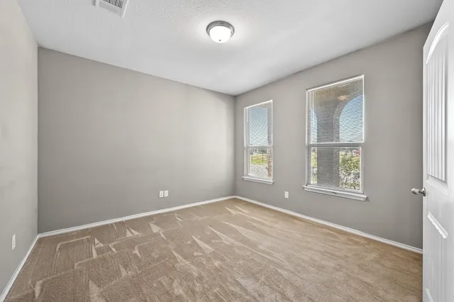 an empty room with windows and closet