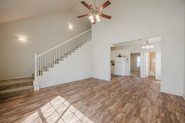 a view of a bedroom with wooden floor and a ceiling fan
