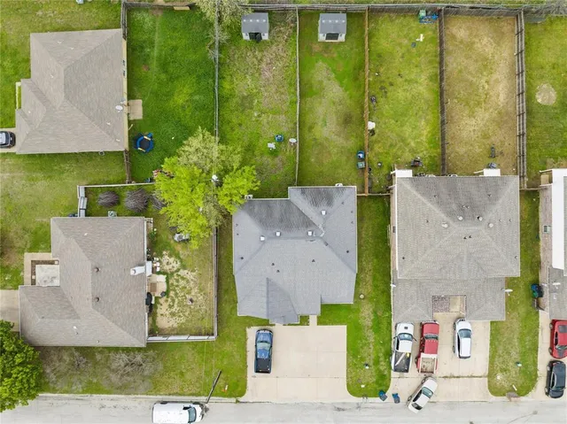 an aerial view of a house with a yard and large tree