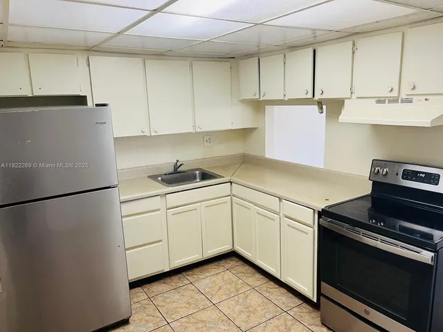 a kitchen with cabinets and a stove top oven