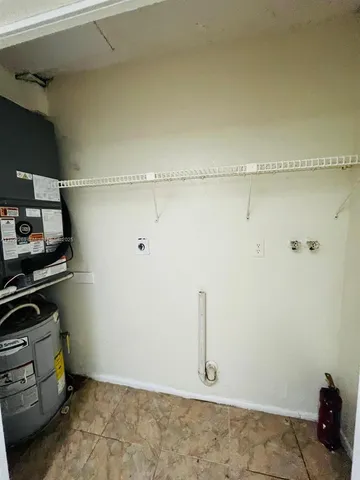 a room with water heater and cabinets
