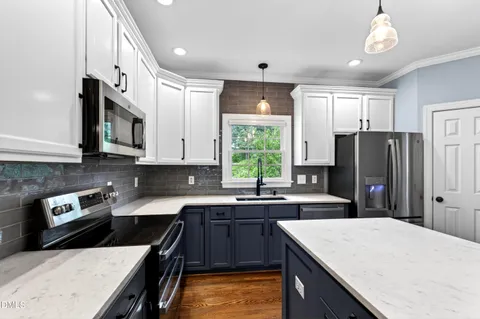 a kitchen with granite countertop a sink a counter top space and stainless steel appliances