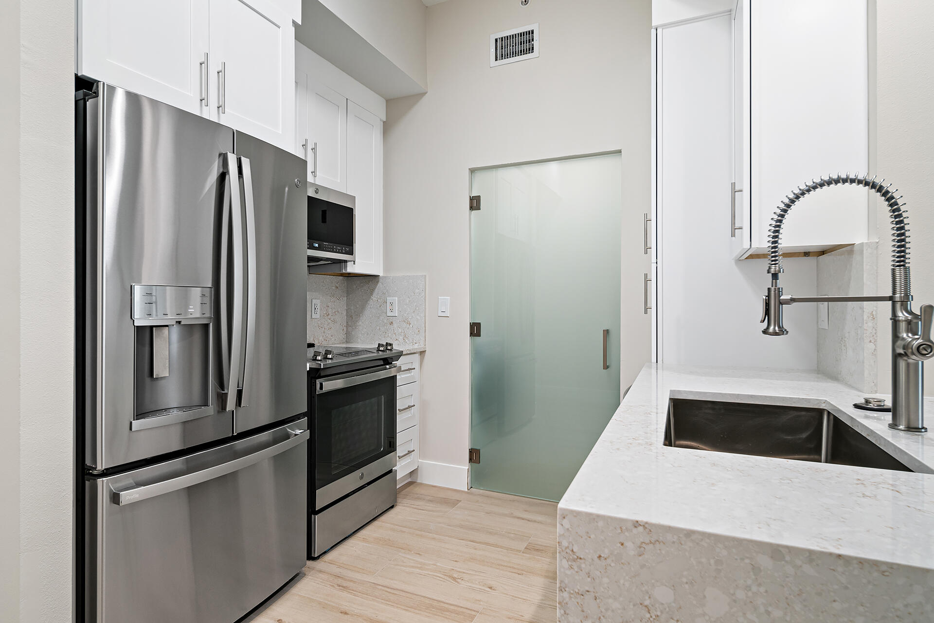 a kitchen with a refrigerator sink and stainless steel appliances