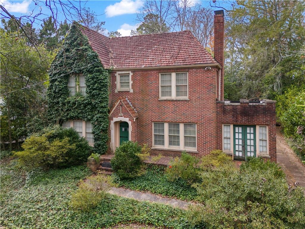 1080 East Clifton Road Northeast Atlanta, GA 30307 - Photo 5 of 29 a brick house with a yard plants and large tree