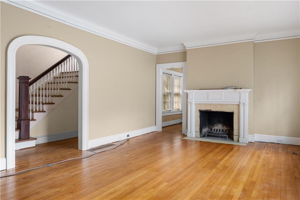 1080 East Clifton Road Northeast Atlanta, GA 30307 - Photo 7 of 29 a view of an empty room with wooden floor fireplace and a window