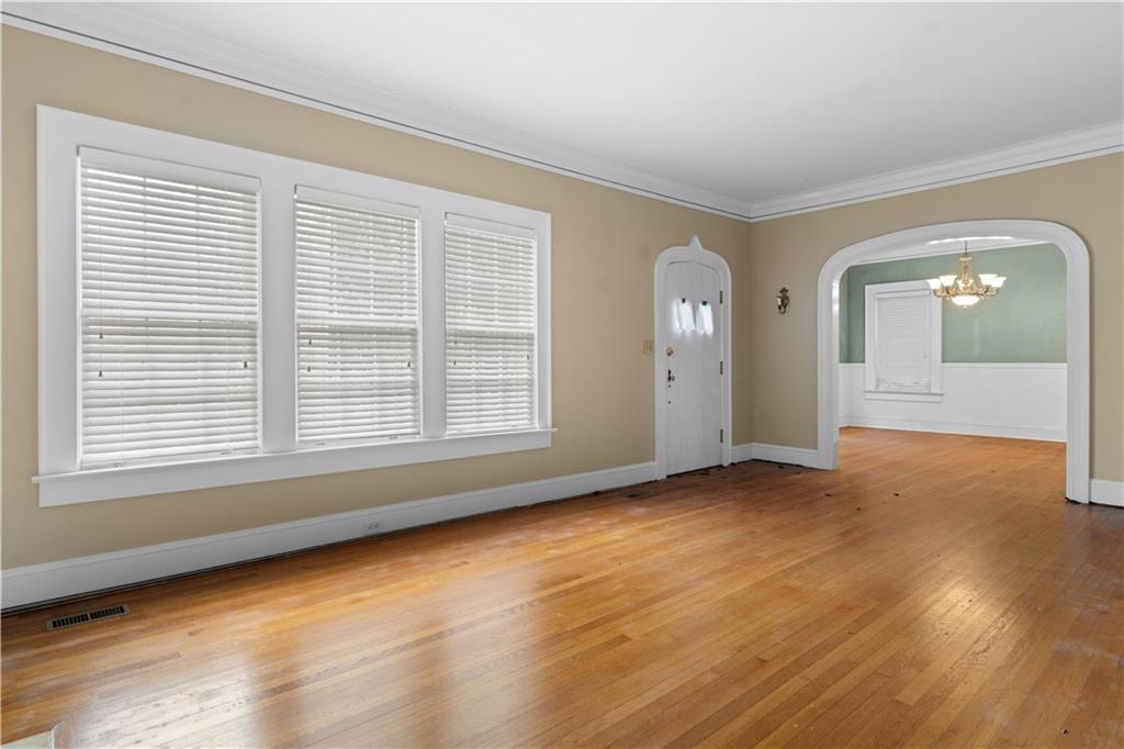 1080 East Clifton Road Northeast Atlanta, GA 30307 - Photo 8 of 29 a view of an empty room with wooden floor and a window