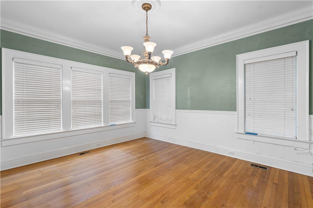 1080 East Clifton Road Northeast Atlanta, GA 30307 - Photo 10 of 29 a view of an empty room with a window and wooden floor