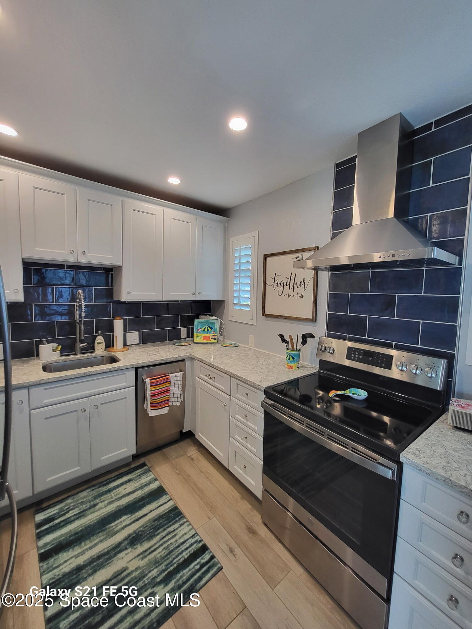 4000 Ocean Beach Boulevard, Unit 4F Cocoa Beach, FL 32931 - Photo 4 of 12 a kitchen with a stove a sink and a refrigerator