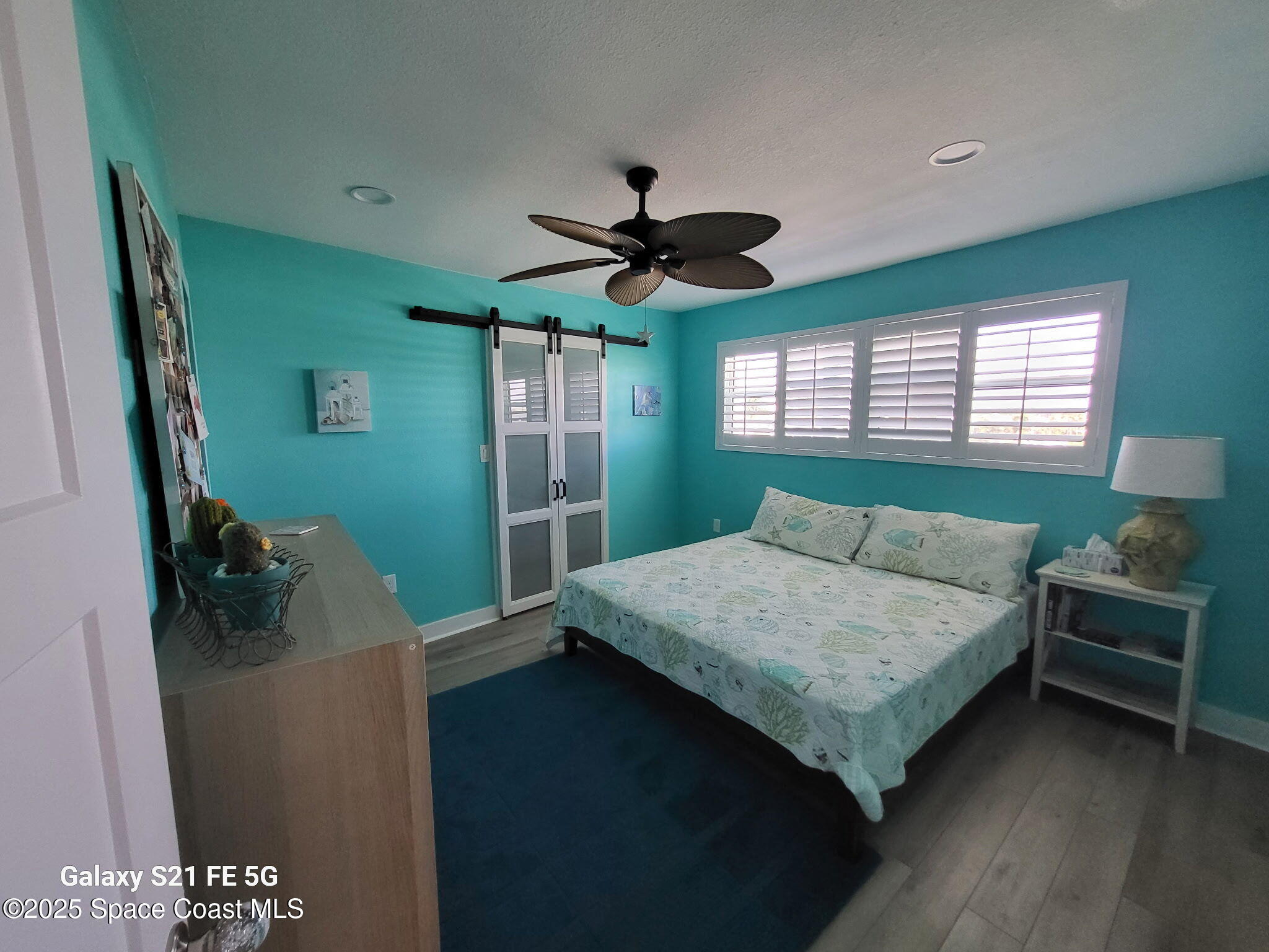 4000 Ocean Beach Boulevard, Unit 4F Cocoa Beach, FL 32931 - Photo 8 of 12 a bedroom with a bed and a chandelier