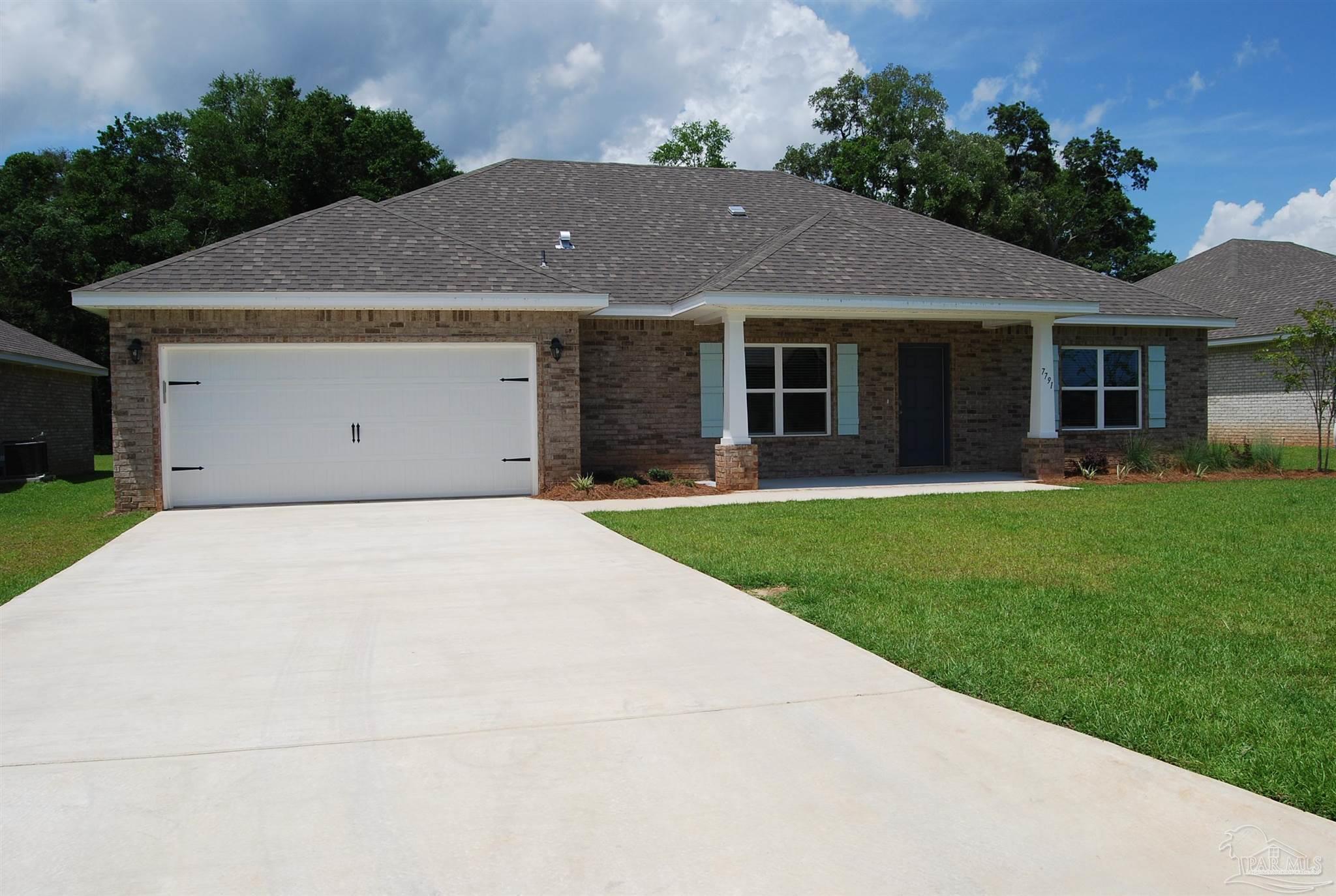 a front view of a house with a yard and trees