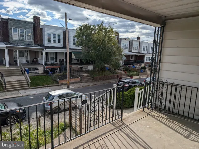 a view of a brick house with large windows and plants