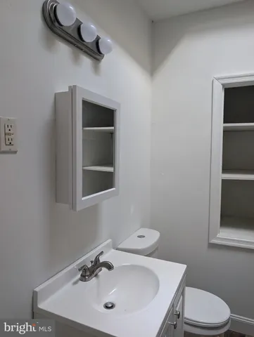 a bathroom with a sink a toilet and vanity