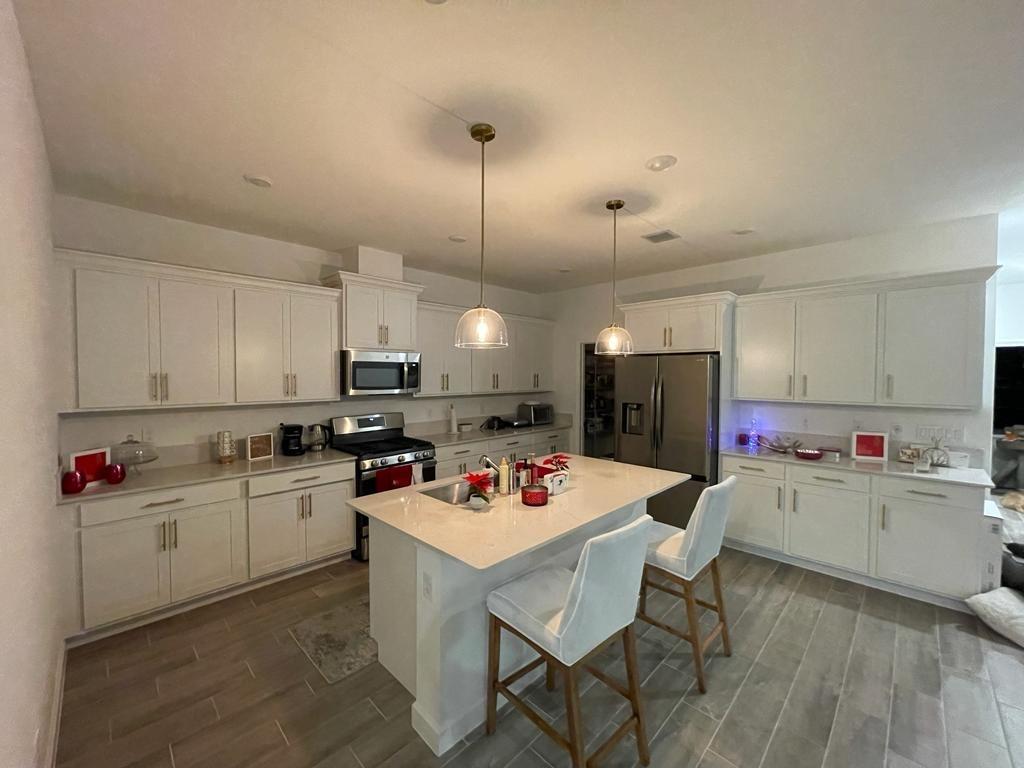 1353 Haywagon Tr. Loxahatchee, FL 33470 - Photo 1 of 34 a kitchen with a stove a sink dishwasher and a refrigerator with wooden floor