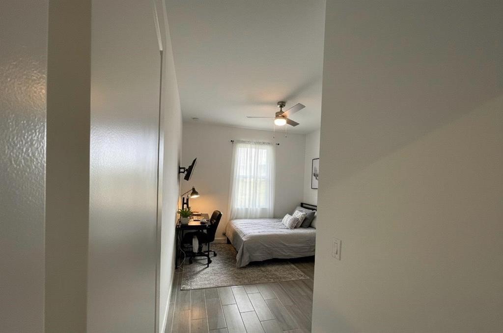 1353 Haywagon Tr. Loxahatchee, FL 33470 - Photo 15 of 34 a bedroom with a bed and a wooden floor