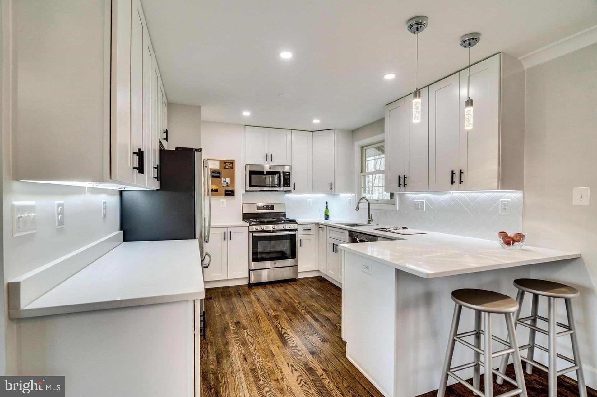 4518 Gage Road Alexandria, VA 22309 - Photo 11 of 42 a kitchen with a sink a stove a refrigerator and white cabinets
