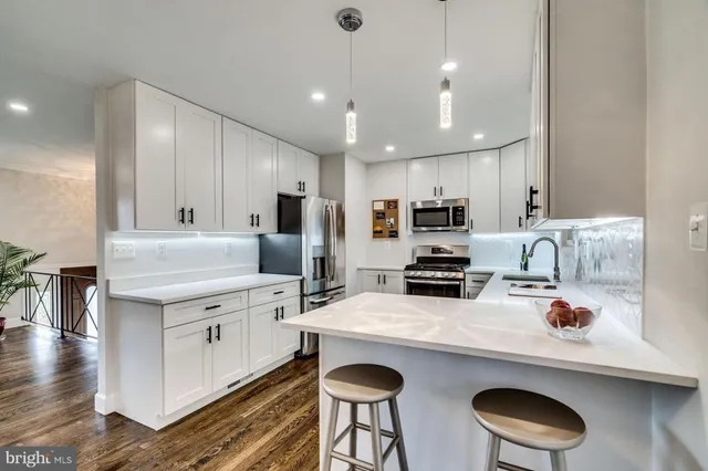 a kitchen with stainless steel appliances a stove a sink a microwave and wooden cabinets