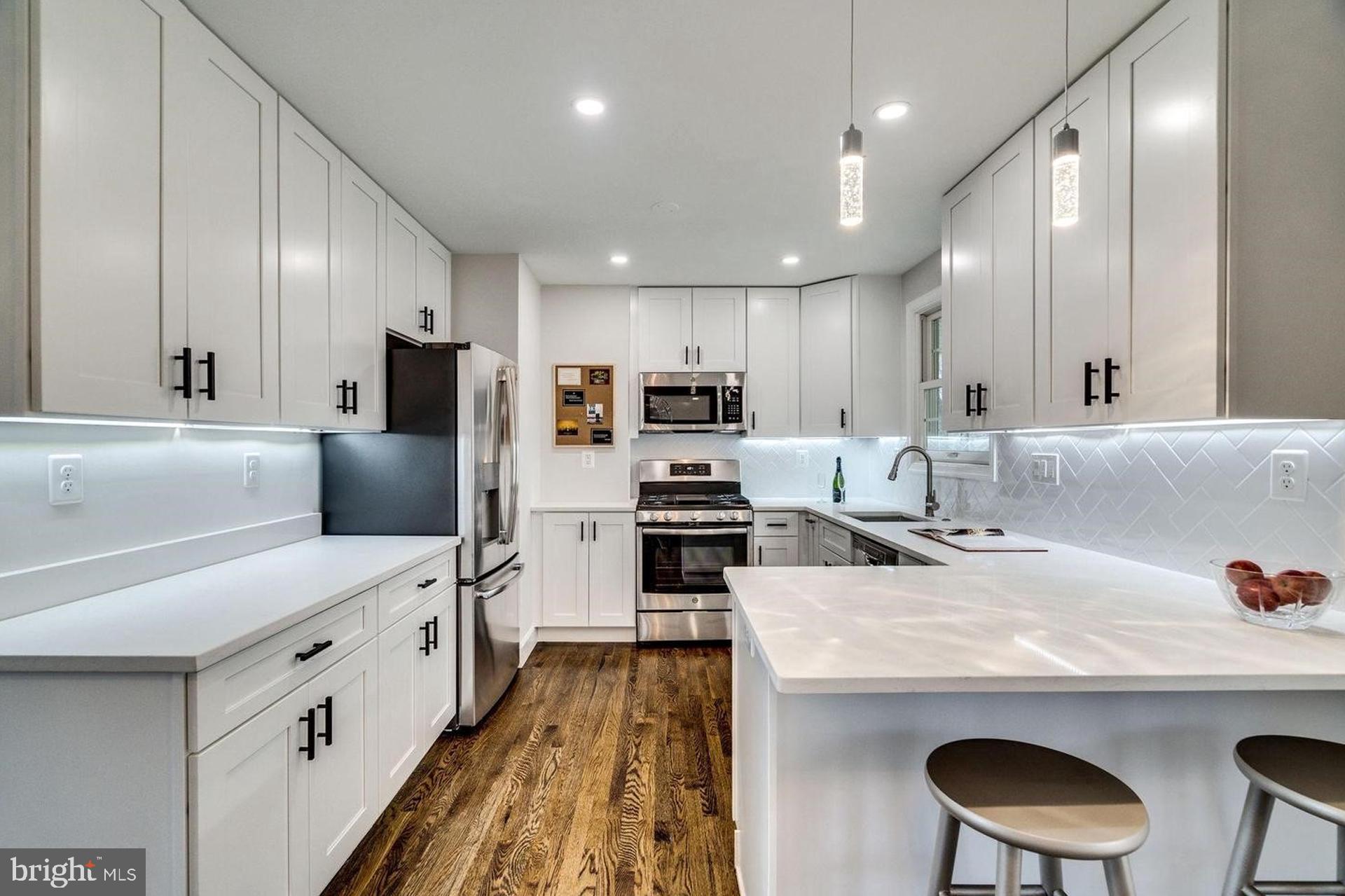4518 Gage Road Alexandria, VA 22309 - Photo 13 of 42 a kitchen with stainless steel appliances a sink a stove a refrigerator cabinets and chairs