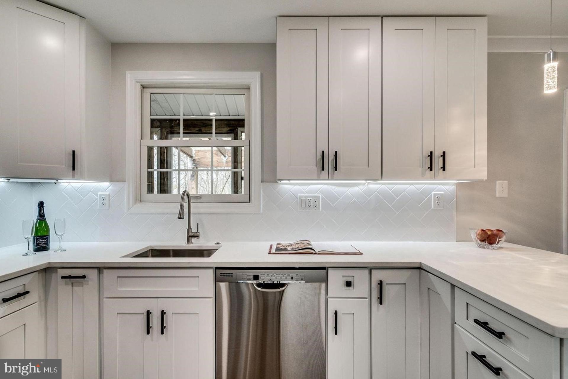 4518 Gage Road Alexandria, VA 22309 - Photo 14 of 42 a kitchen with stainless steel appliances granite countertop a sink and cabinets with wooden floor