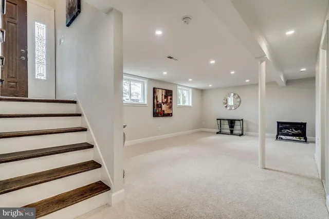 an entryway in a hall with a window and furniture