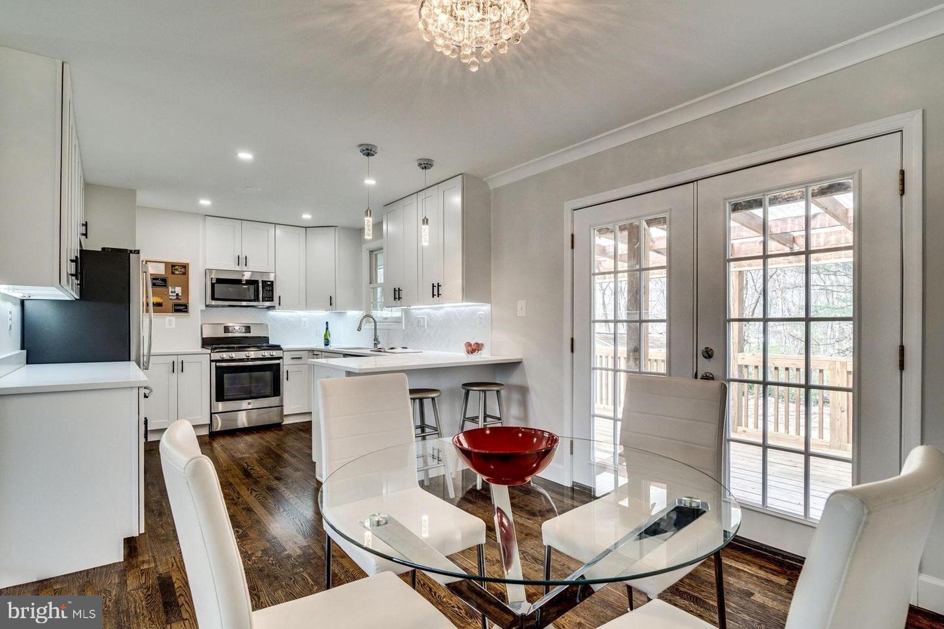 4518 Gage Road Alexandria, VA 22309 - Photo 10 of 42 a kitchen with stainless steel appliances granite countertop a stove a refrigerator a sink dishwasher a dining table and chairs with wooden floor