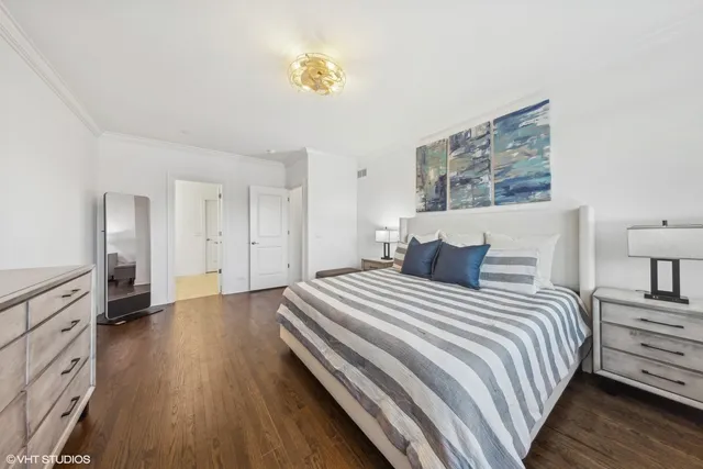 a spacious bedroom with a bed and painting on the wall