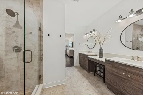 a bathroom with a double vanity sink mirror and shower