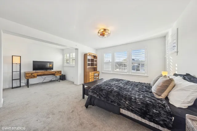 a bedroom with a bed and a flat tv screen on the dresser