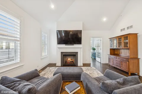 a living room with furniture a flat screen tv and a fireplace