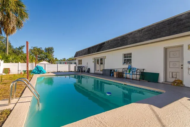 a swimming pool with outdoor seating and yard
