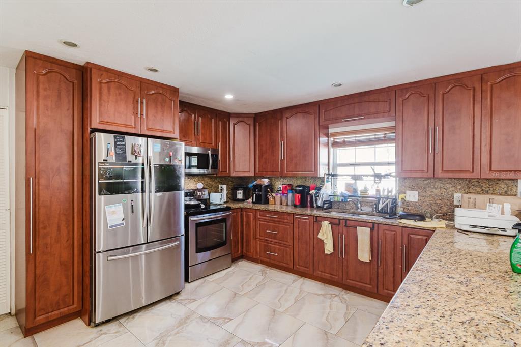 104 Druid Hills Road Temple Terrace, FL 33617 - Photo 3 of 22 a kitchen with stainless steel appliances granite countertop a refrigerator stove top oven and sink