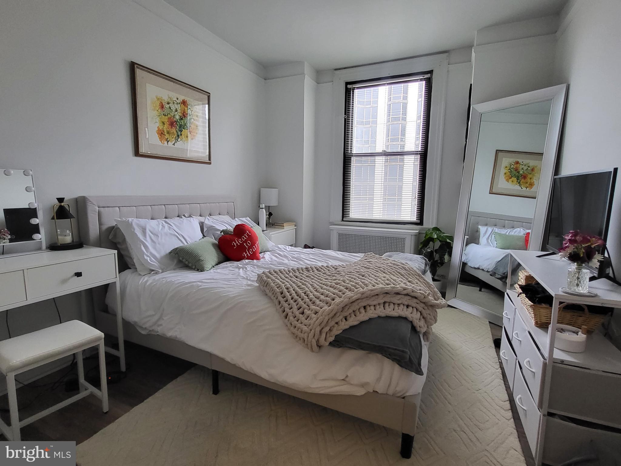 2031 Locust Street, Unit 1503 Philadelphia, PA 19103 - Photo 12 of 24 a bedroom with a bed a couch and a window