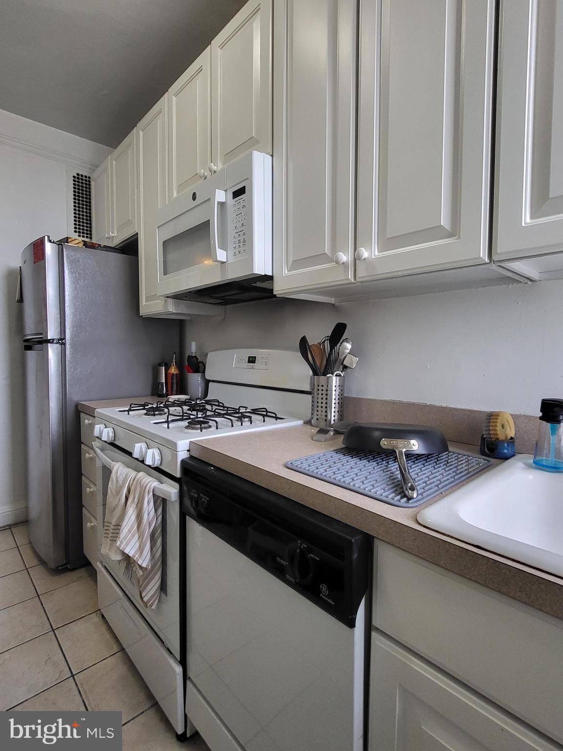 2031 Locust Street, Unit 1503 Philadelphia, PA 19103 - Photo 6 of 24 a kitchen with stainless steel appliances granite countertop a sink and dishwasher a stove top oven