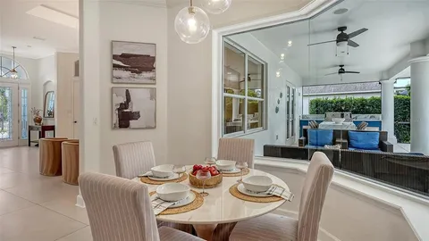 a view of a dining room with furniture a kitchen and chandelier
