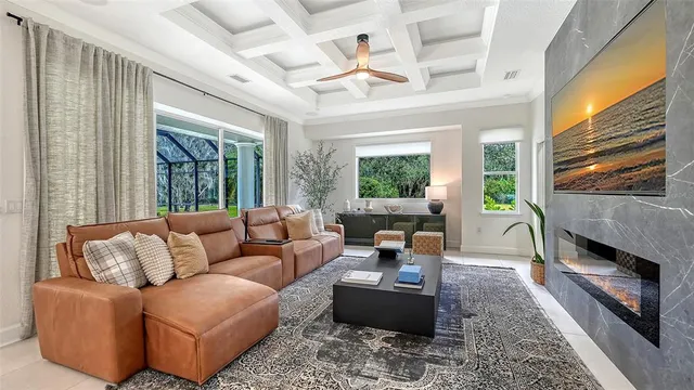 a living room with furniture fireplace and a large window