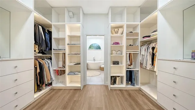 a view of walk in closet with clothes and shoes